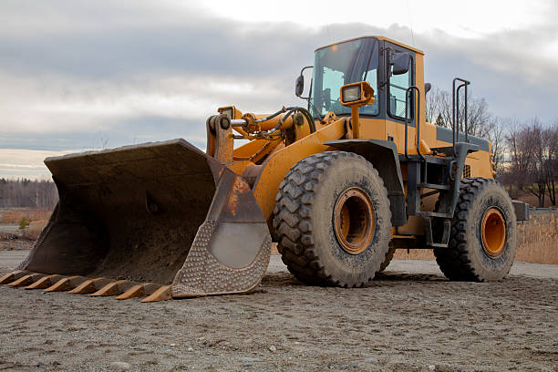 A robust, heavy-duty loader with big wheels and a wide shovel at an outdoor construction site.Perfect for industrial visuals.